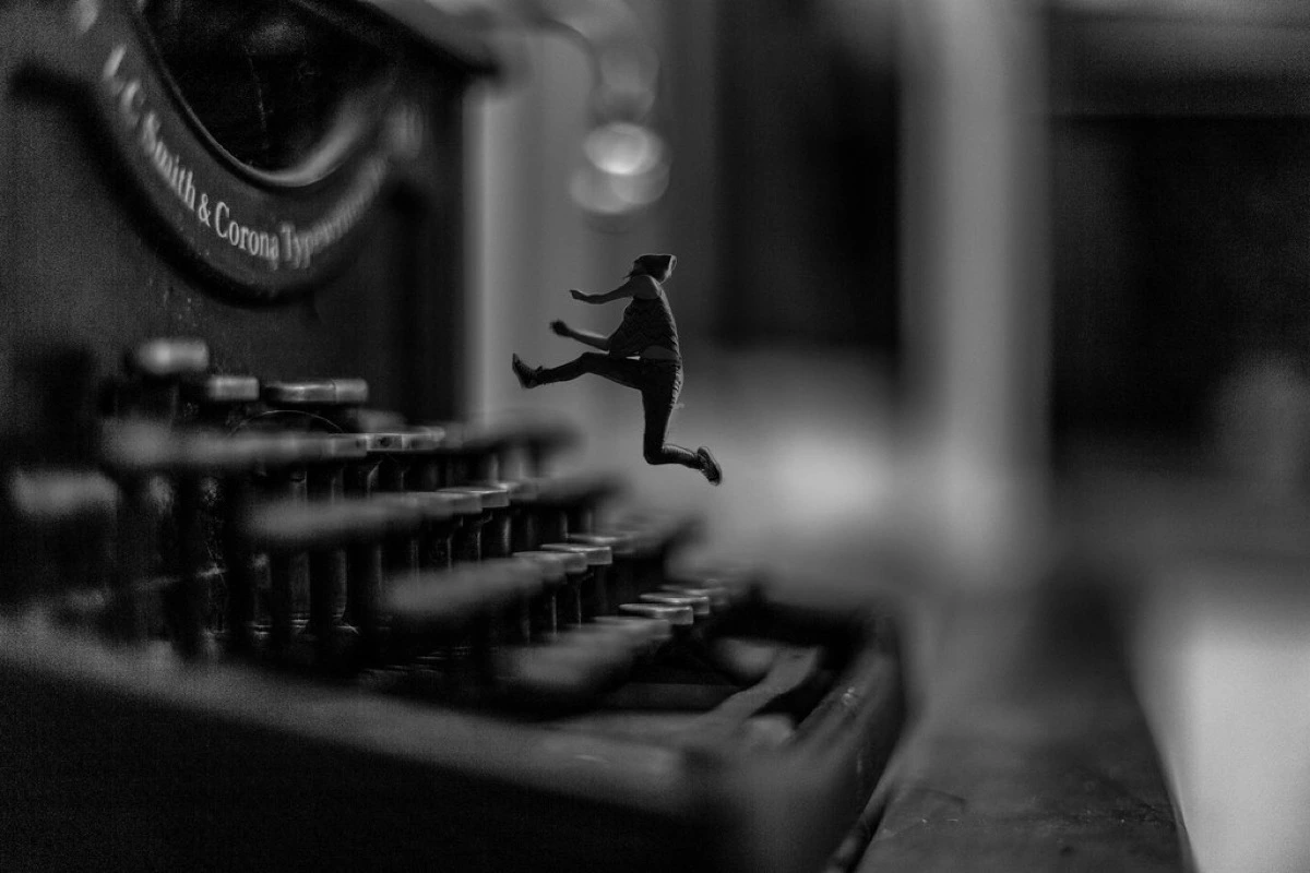 Miniatuurfiguur springt over de toetsen van een oude typemachine